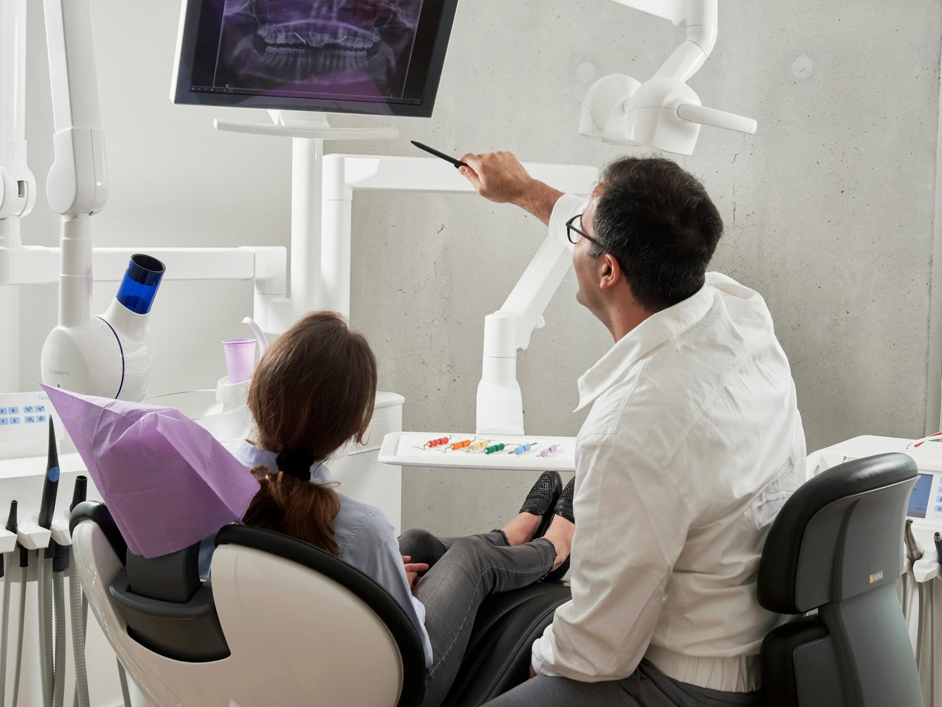 A dentist reviewing a patient's x-ray together in a bright, modern operatory